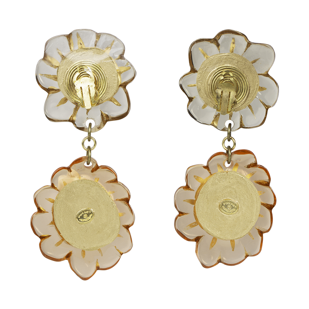Pair of floral earrings with gold and white design on a white background